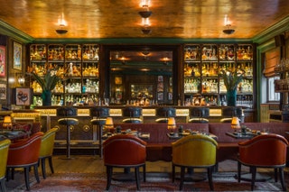 Timber flooring a sealed copperleaf ceiling leather armchairs and tiletopped tables in the Mexican Bar.