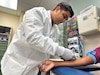 Spc. Galen Bringas, 7459th Medical Operations Readiness Unit, draws blood from a patient at Winn Army Community Hospital’s lab Aug. 7 on Fort Stewart. The Army Reserve unit is currently training at the hospital and stepped up to fill staffing gaps created by Tropical Storm Debby.