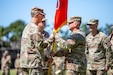 Brig. Gen. Kevin Meisler passes to colors to Lt. Gen. James B. Jarrard during the 311th Signal Command (Theater) change of command ceremony at historic Palm Circle in Fort Shafter on July 19, 2024.