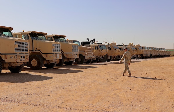 Army Soldiers walks to tactical vehicles staged for reception.