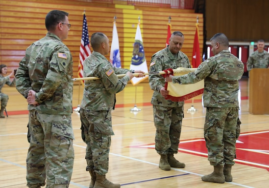 364th ESC commanding general and command sergeant major roll the unit guidon during their farewell ceremony, in preparation for mobilizing overseas.