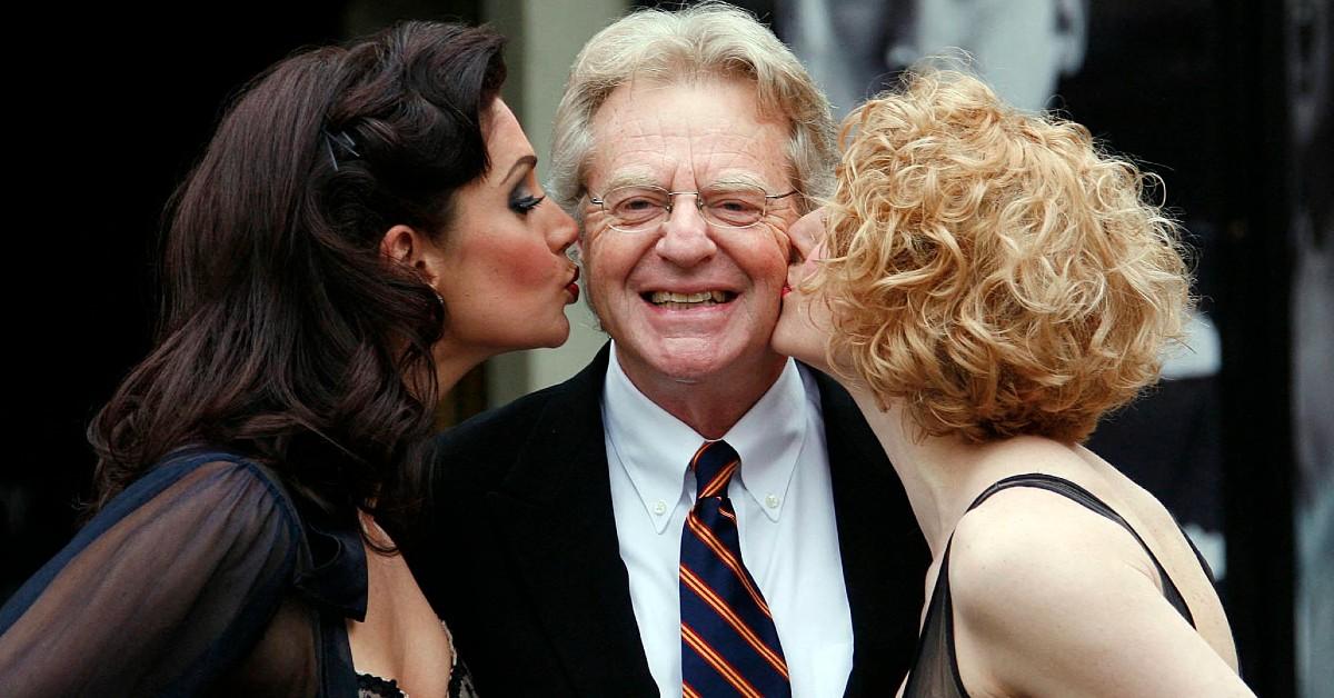 Jerry Springer posing with cast of a musical