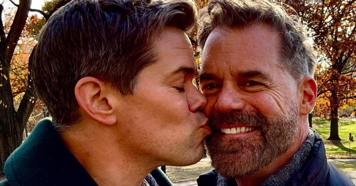 Andrew Rannells kissing his partner Tuc Watkins at the park.