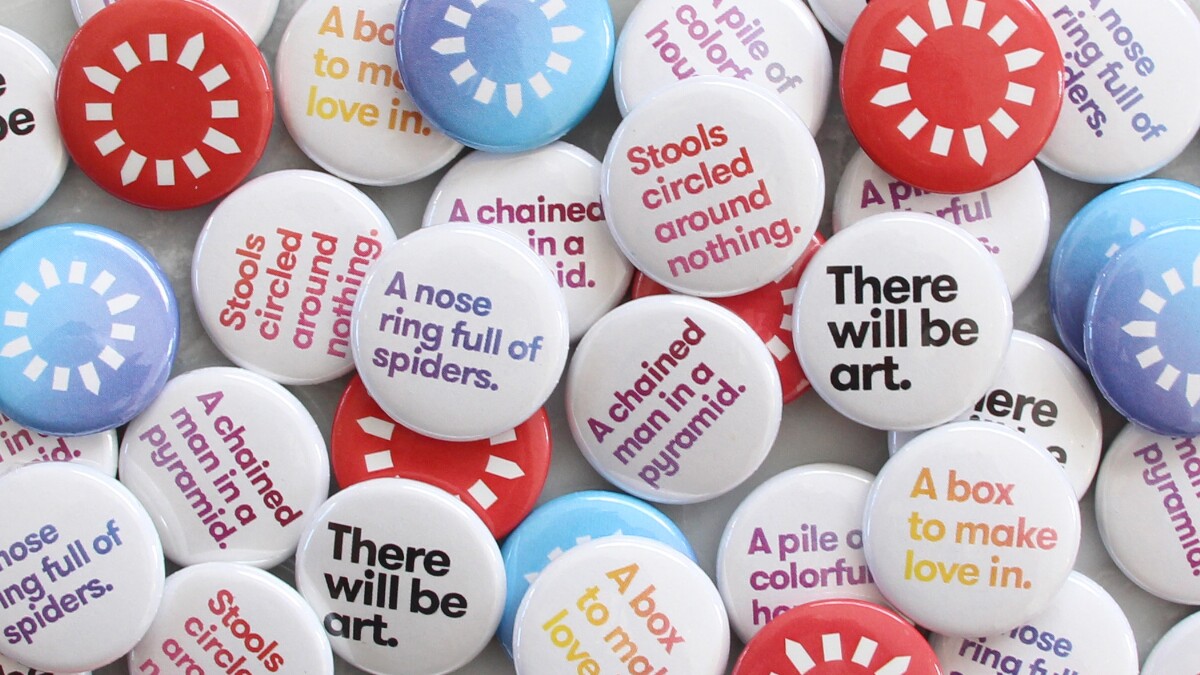 a pile of white, red, and blue lapel pins with phrases related to Pacific Standard Time written on them