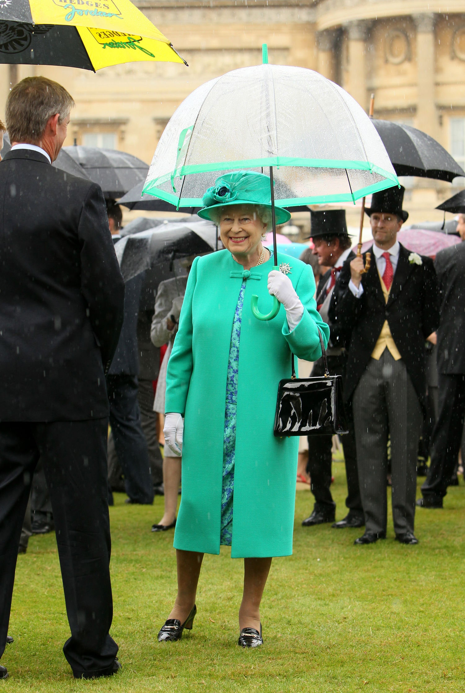 Image may contain Elizabeth II Human Person Clothing Apparel Coat Overcoat Suit Tie Accessories and Accessory