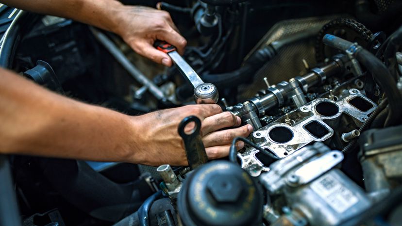 A car mechanic fixing a car engine in a garage. 