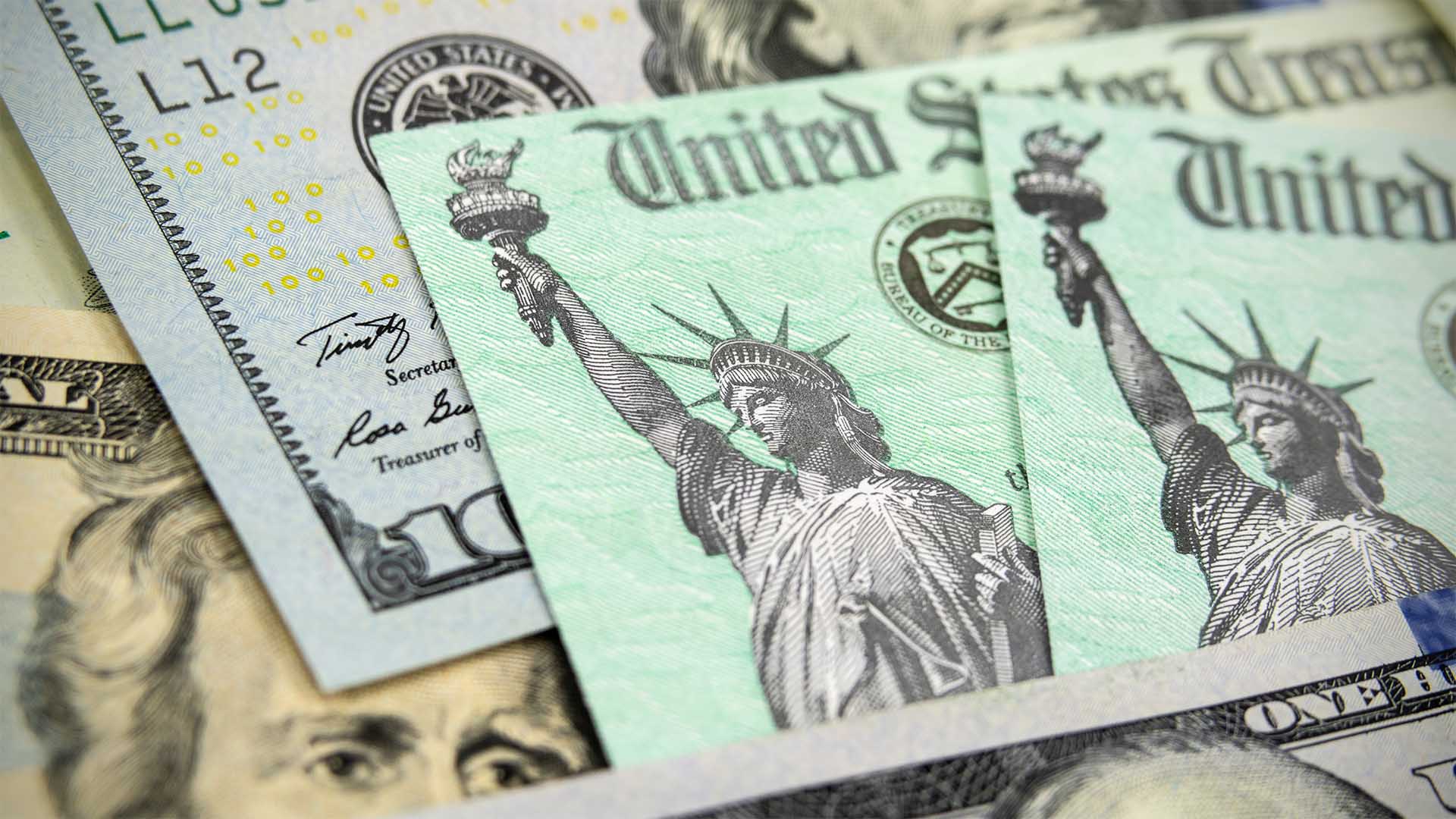 Macro view of the Statue of Liberty on a United States Treasury Checks with currency in background