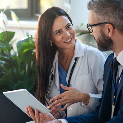 healthcare worker talking to business person 