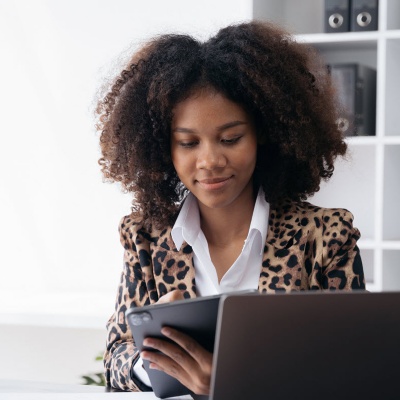 Kantoormedewerker achter een bureau aan het werk op een tablet.