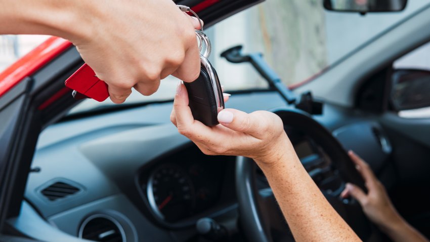 Salesman handling keys to customer