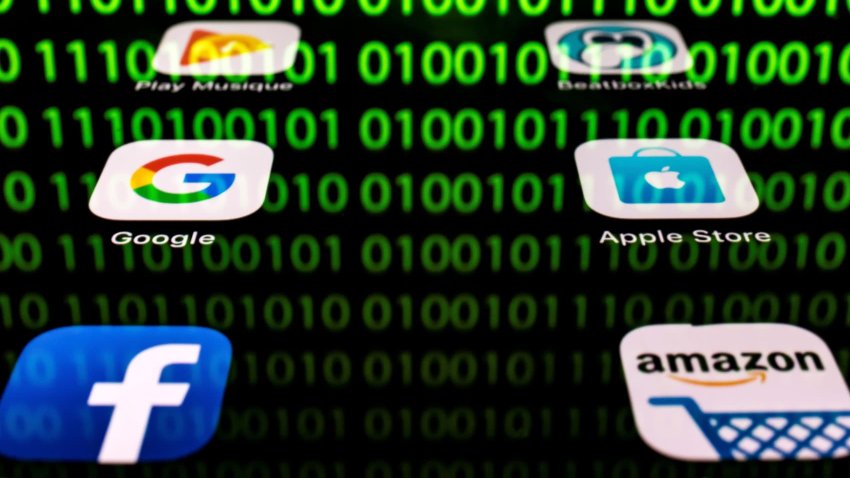 This illustration picture taken on April 20, 2018 in Paris shows apps for Google, Amazon, Facebook, Apple (GAFA) and the reflexion of a binary code displayed on a tablet screen. (Photo by Lionel BONAVENTURE / AFP)        (Photo credit should read LIONEL BONAVENTURE/AFP via Getty Images)