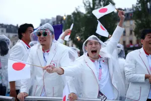 ▲巴黎奧運開幕式在塞納河舉行，運動員搭船進場，但現場雨勢變大，日本運動員也只能撐傘或穿雨衣。（圖／美聯社／達志影像）