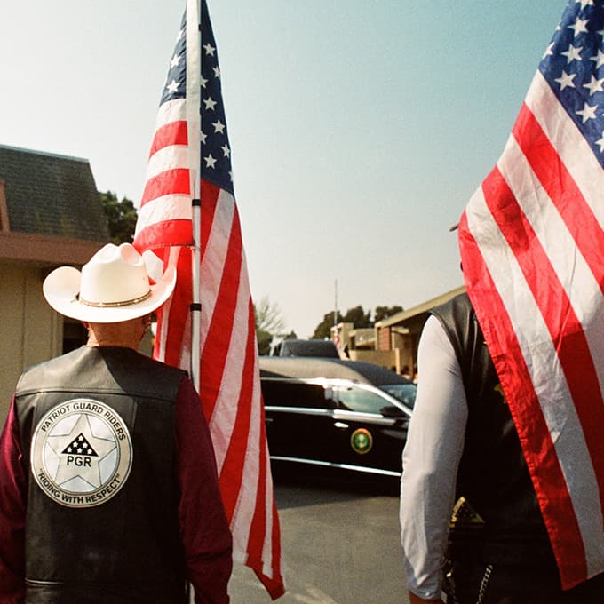 Two people standing with the American flags