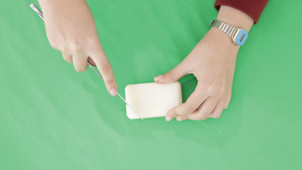 Photograph of a pair of hands carving soap