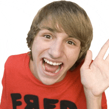 a young man wearing a red shirt with the letters fred on it