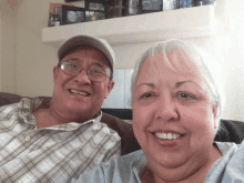 a man and woman are posing for a picture in front of a shelf with pictures on it including one that says lucas