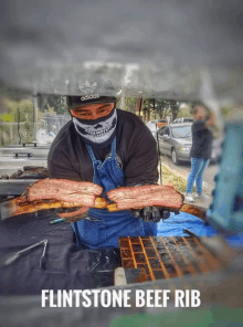 a man wearing an adidas hat is holding a piece of beef