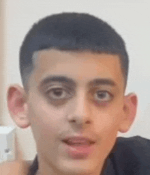 a close up of a young man 's face with a very serious look on his face .