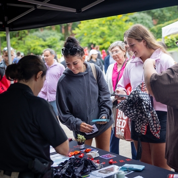 Students gather at an information booth on Ho Plaza. 