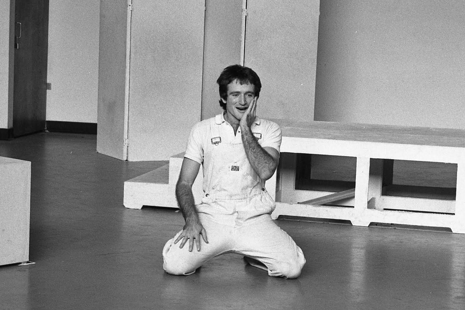 Robin Williams wears all white jumpsuit.