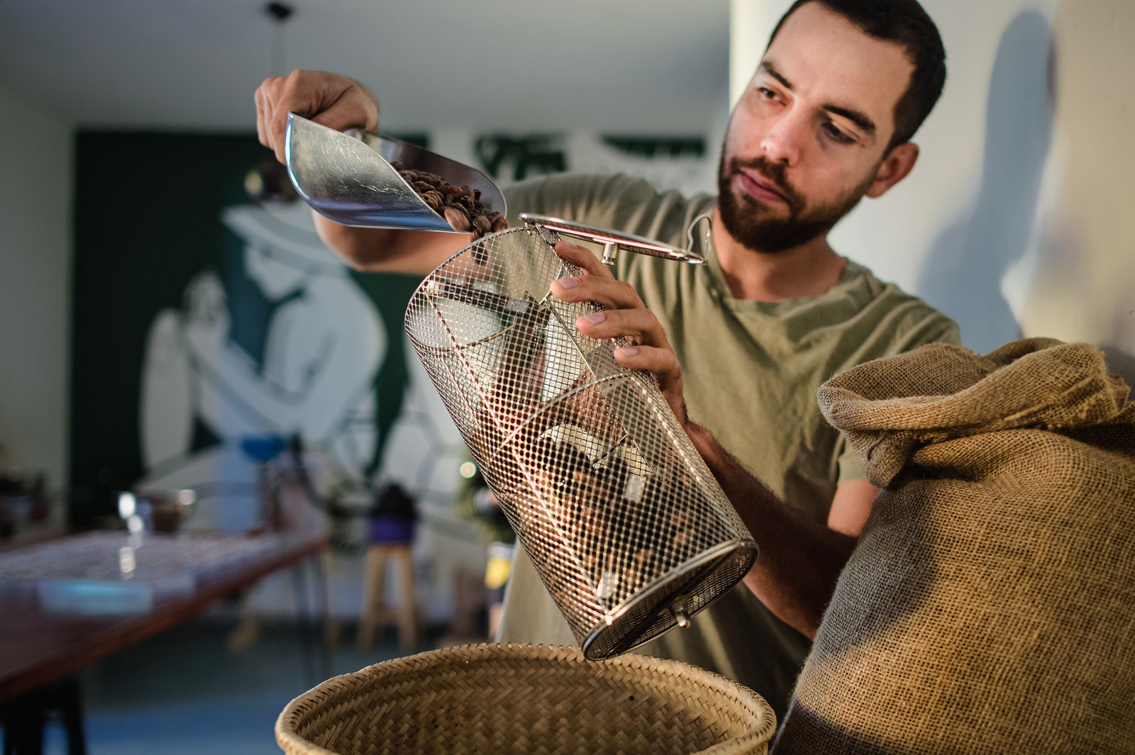 Person pouring cocoa beans into container