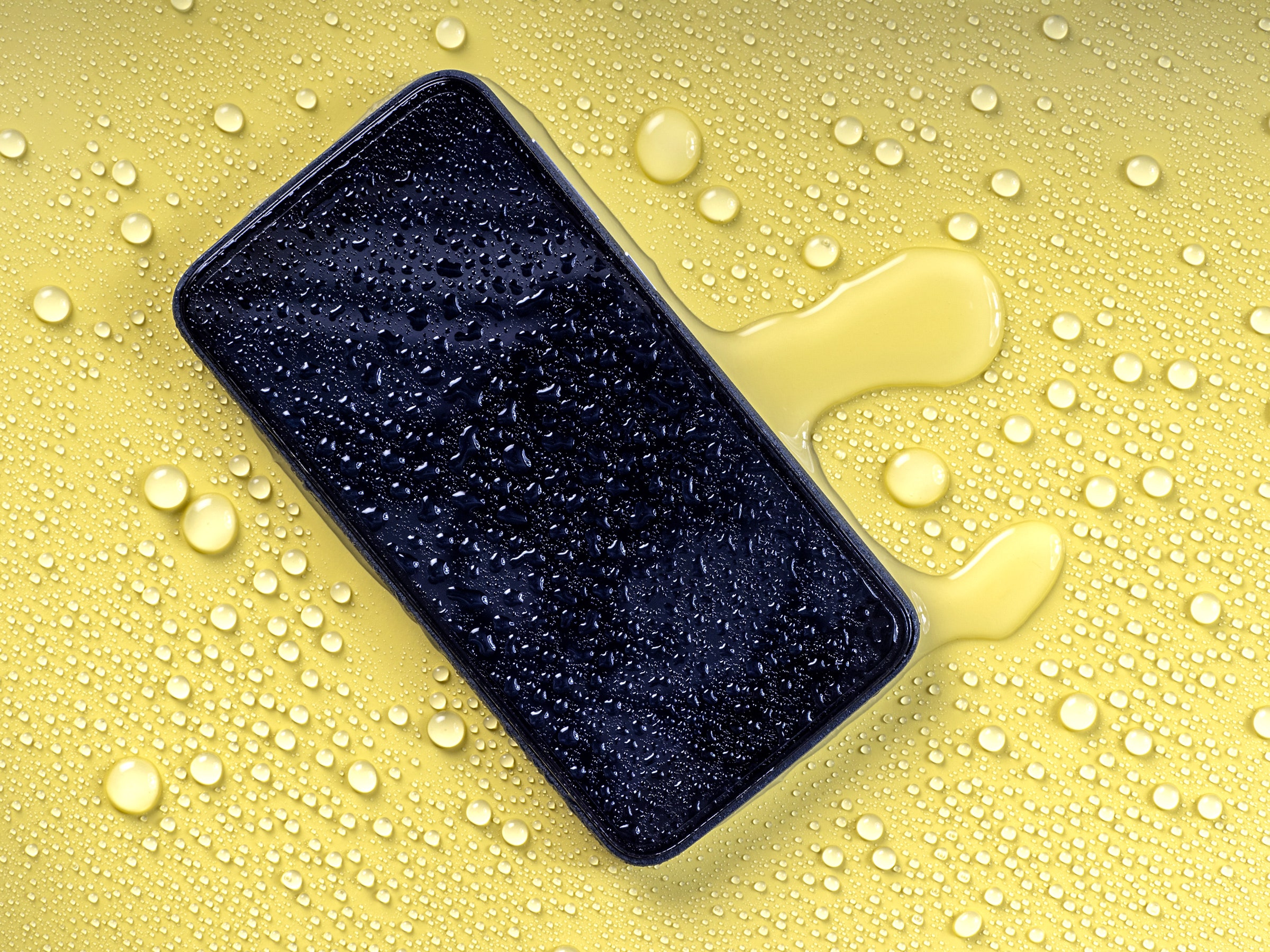 Phone covered in water and water droplets