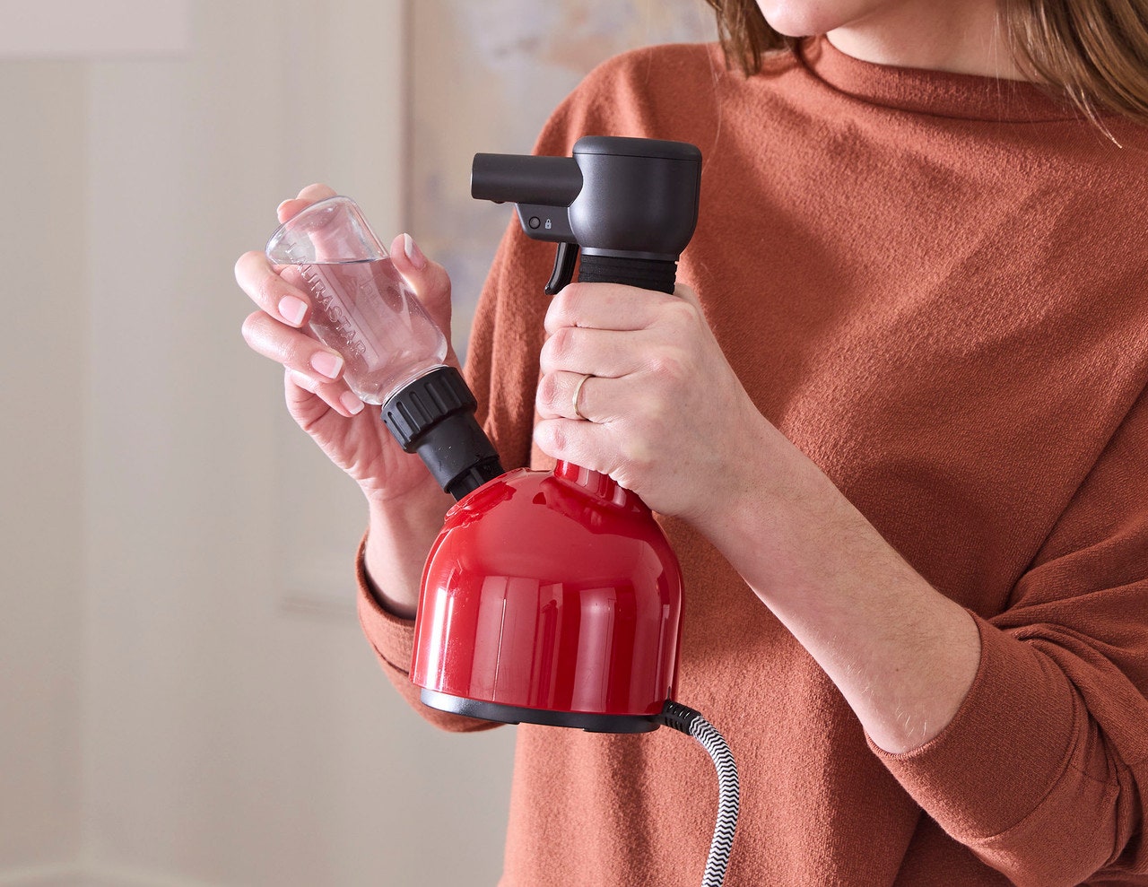 Person refilling the Laurastar Iggi steamer with water