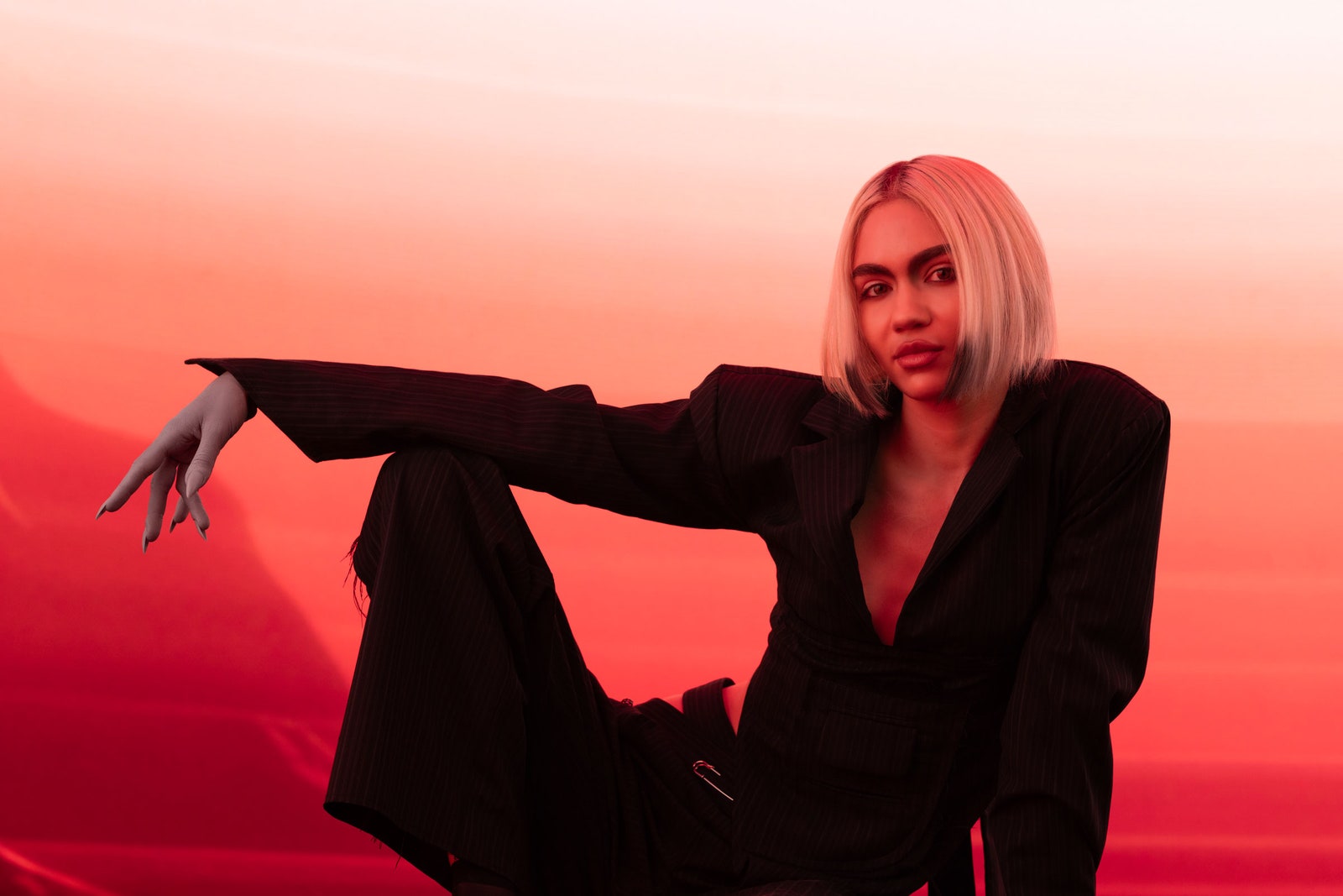 Grimes with a Mars inspired backdrop with her hand and nails painted gray