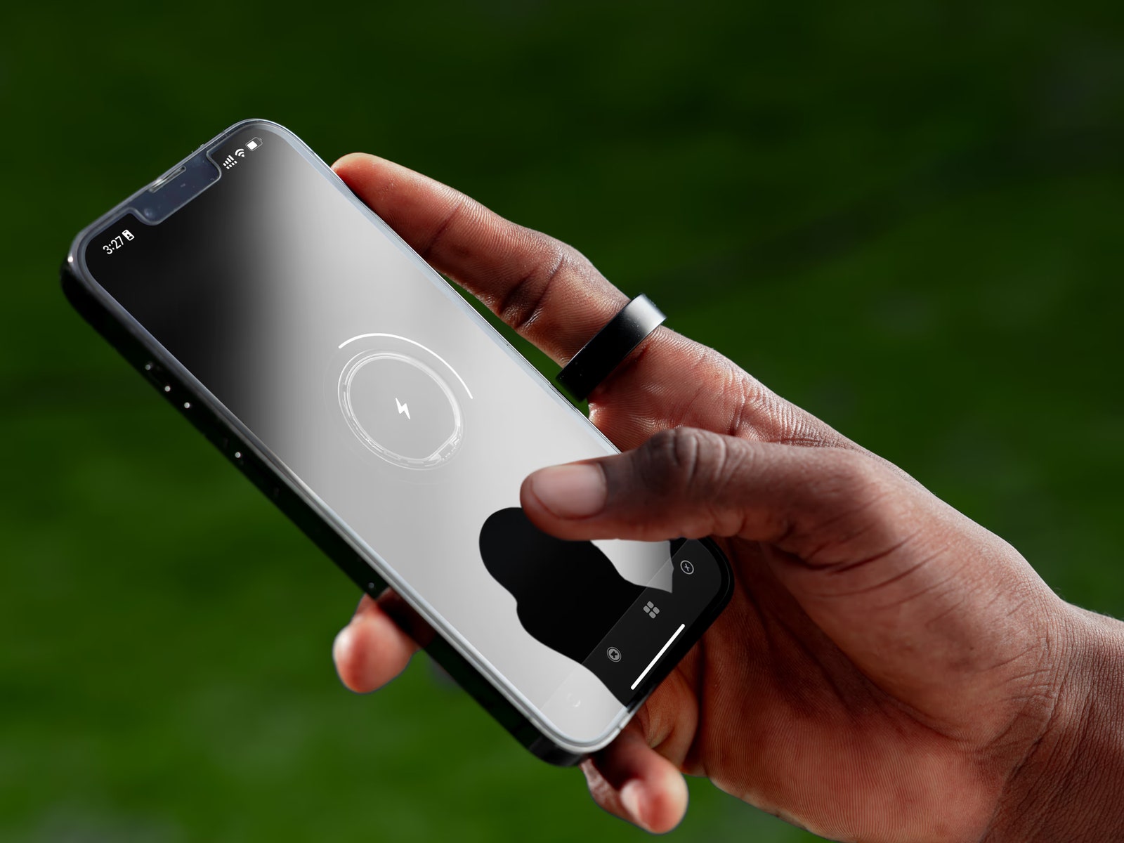 Closeup of a person's hand wearing a Ultrahuman Ring Air and using a smartphone