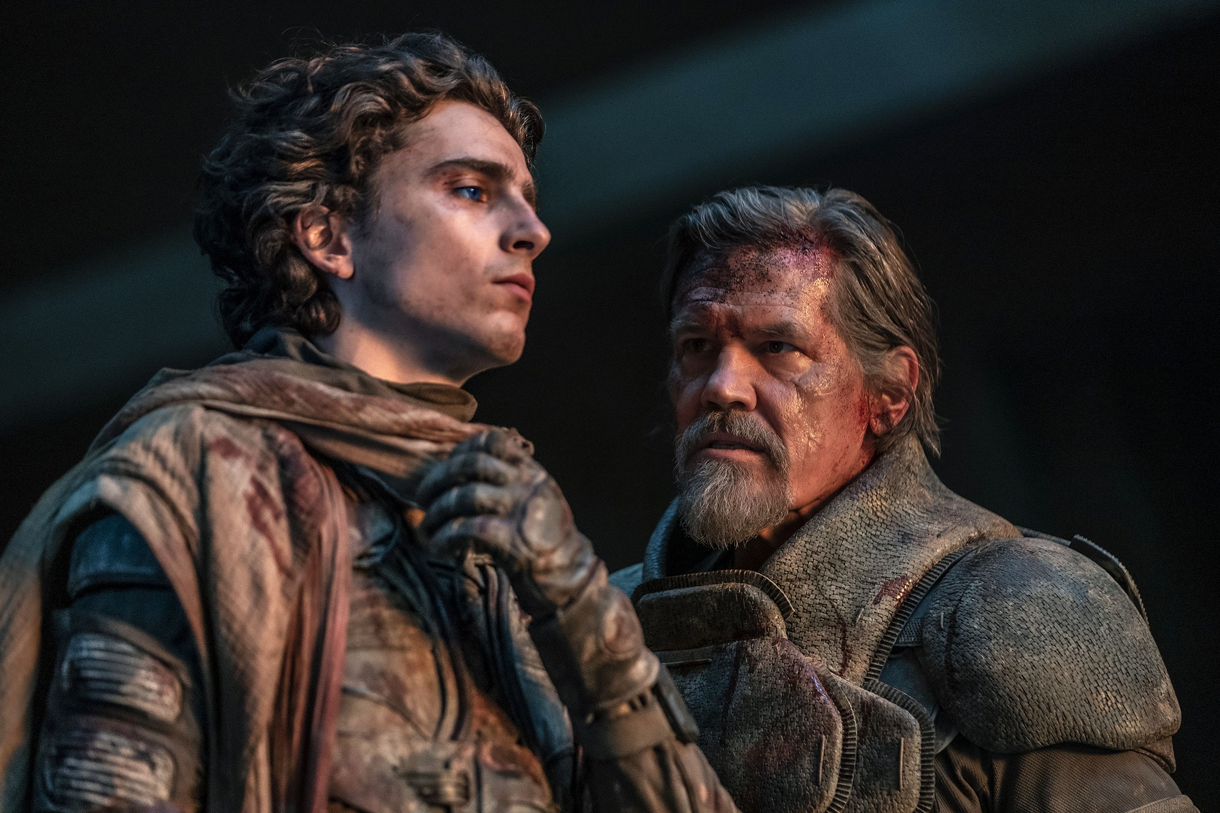 Timothe Chalamet as Paul Atreides and Josh Brolin as Gurney Halleck with blood and dirt on their faces