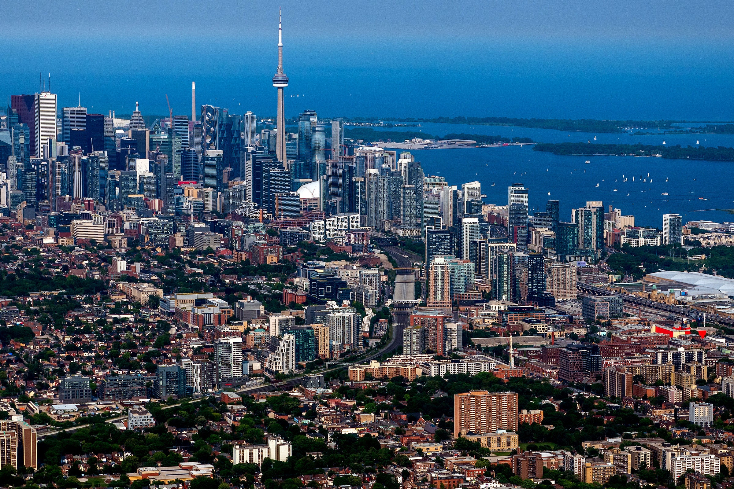 Aerial view of commercial and residential buildings in Toronto with a large body of water in the distance