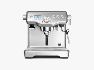 Silver espresso machine with dials spouts and small screen