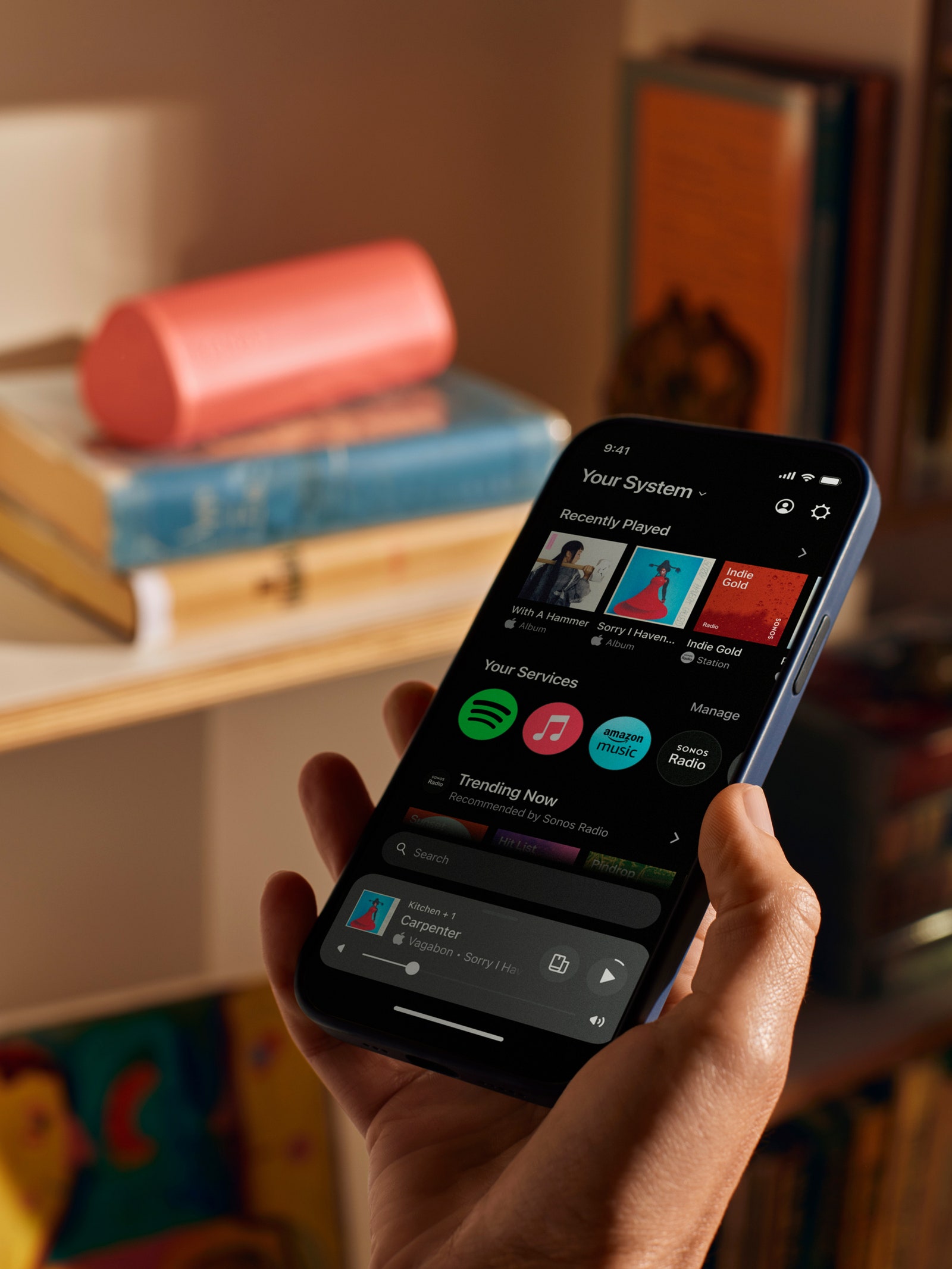 Person using the Sonos app next to a Sonos speaker