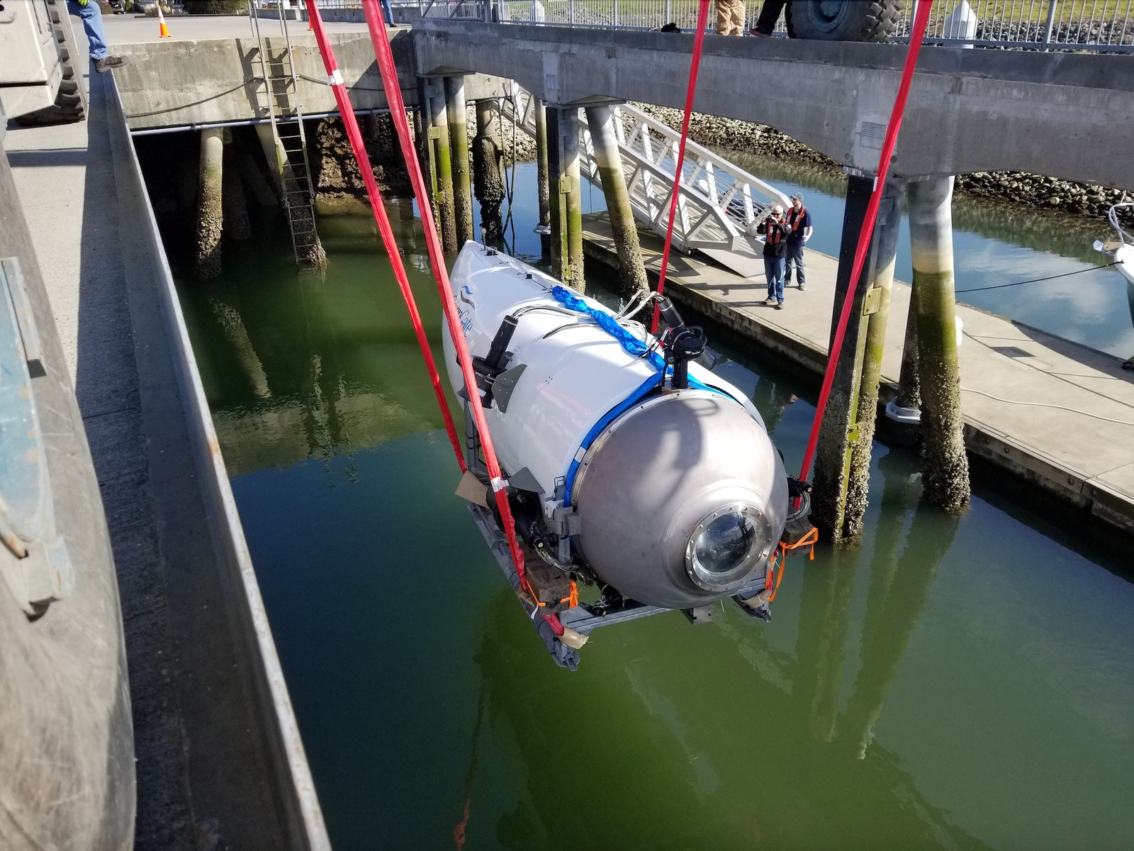 Photograph of Titan submersible being lowered into water by a sling system