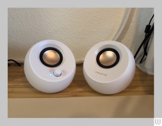 2 round white speakers with gold centers