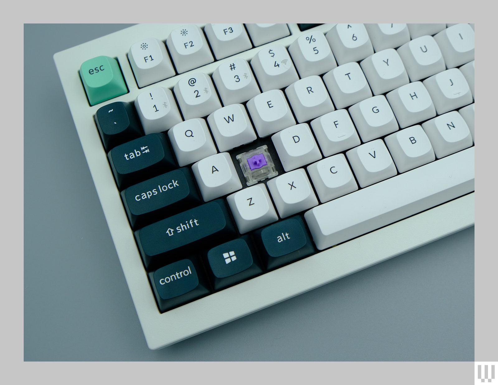 Closeup of a computer keyboard with a keycap missing displaying the parts underneath