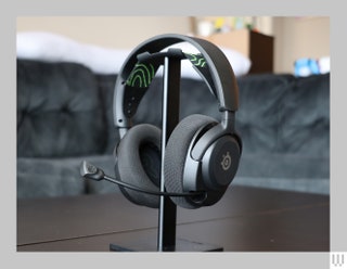 Black headset with cushioned ear cups padded headband and extended mic hooked on a tabletop stand