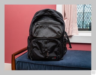 Front view of black backpack with multiple zippered pouches in the front