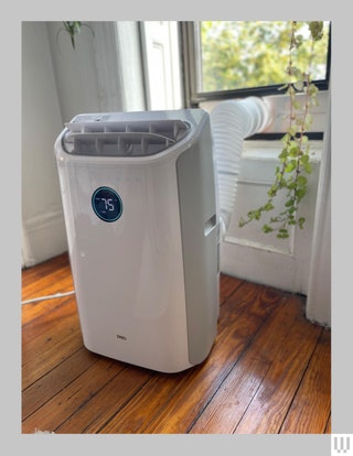 Vertical mobile air conditioner on wheels connected to a window through a collapsible tube