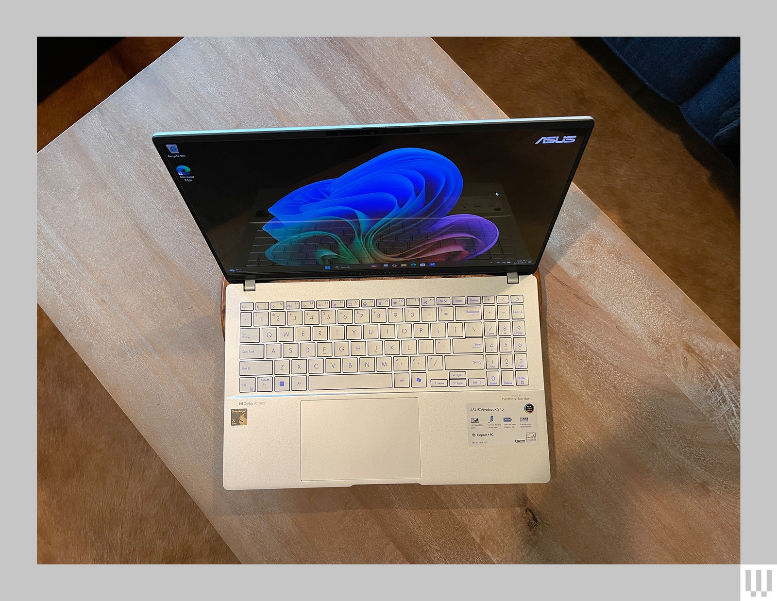 Overhead view of slim silver laptop opened and sitting on a wooden table