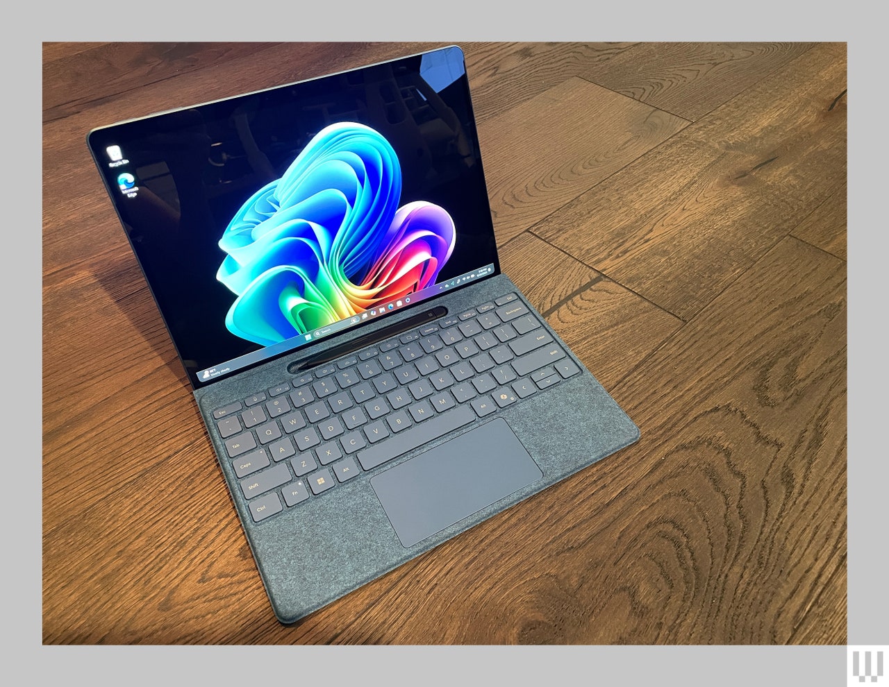 Microsoft Surface Pro tablet connected to detachable keyboard, sitting on wooden floor.