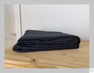 Folded black sheets sitting on a wooden surface