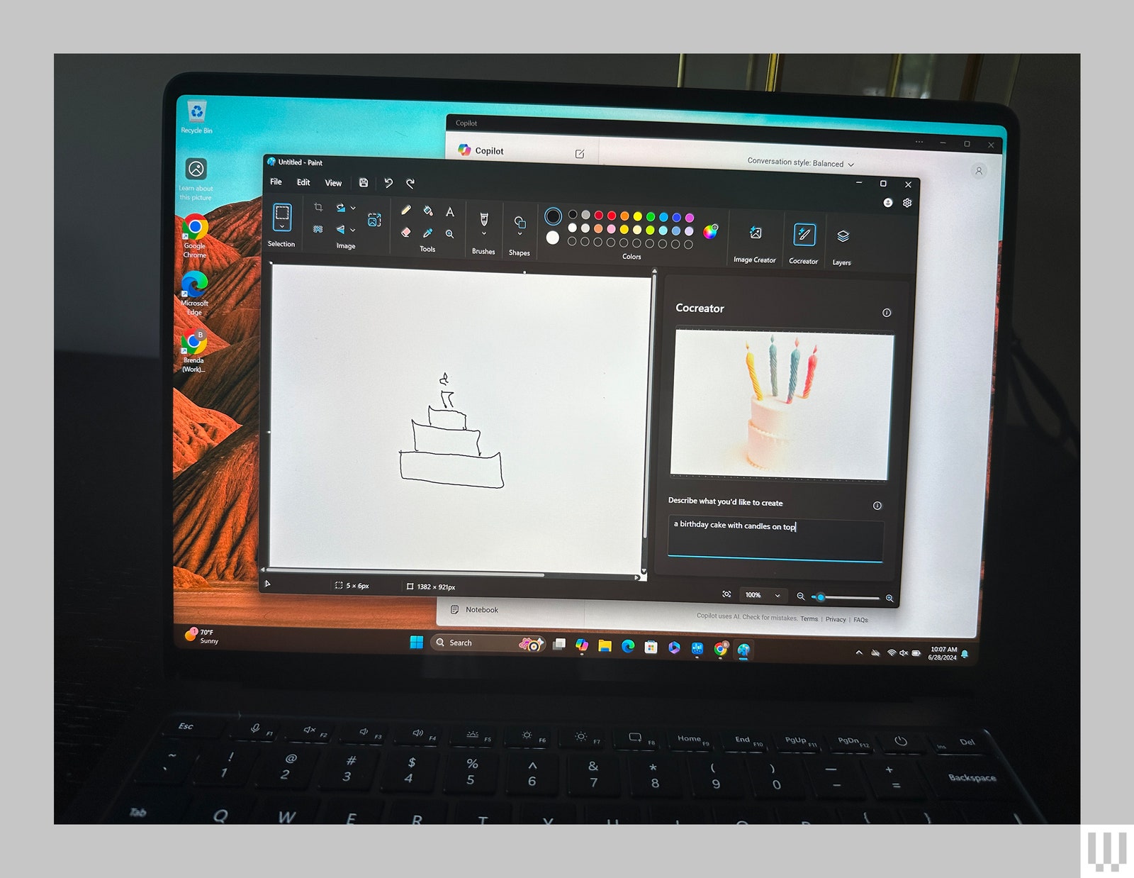 Laptop screen showing a sketch of a birthday cake with candles on the left and an artificially generated birthday cake...