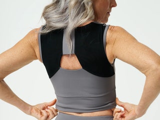 Person wearing grey and black top with black padding near the shoulders