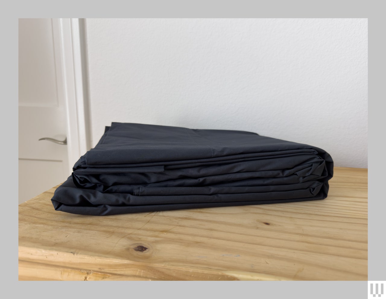 Black sheets folded on top of a wooden surface