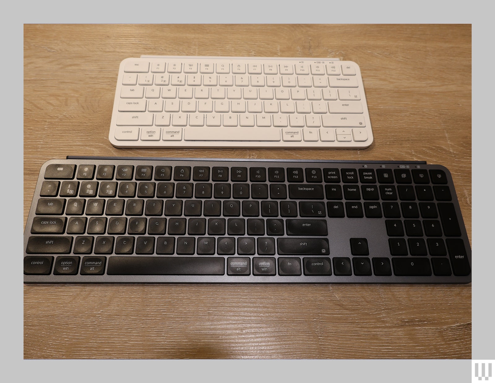 Small white computer keyboard near a larger black computer keyboard