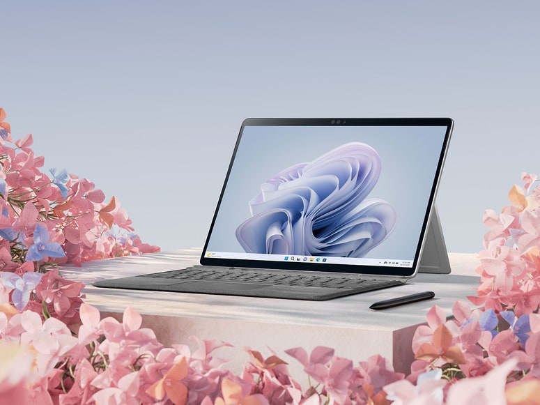 Microsoft Surface Pro 9 on desk surrounded by colorful flowers