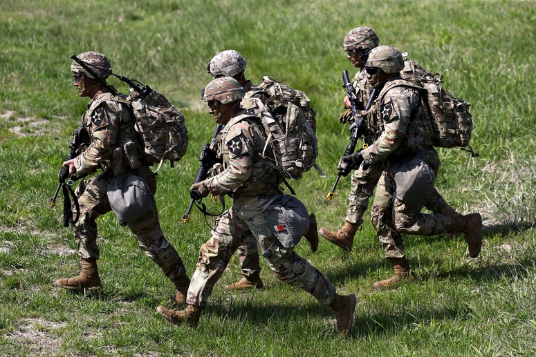 U.S. soldiers from the 2nd Infantry Division walking in a grass field