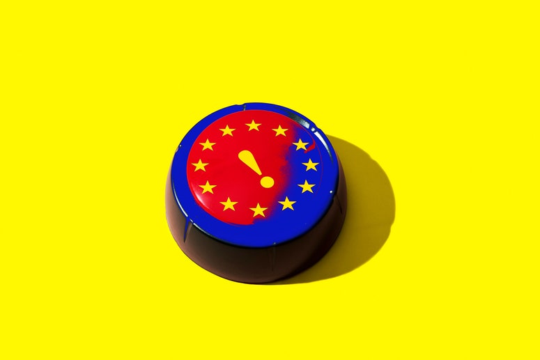 A red button with the EU flag and a yellow exclamation mark on it photographed on a yellow background