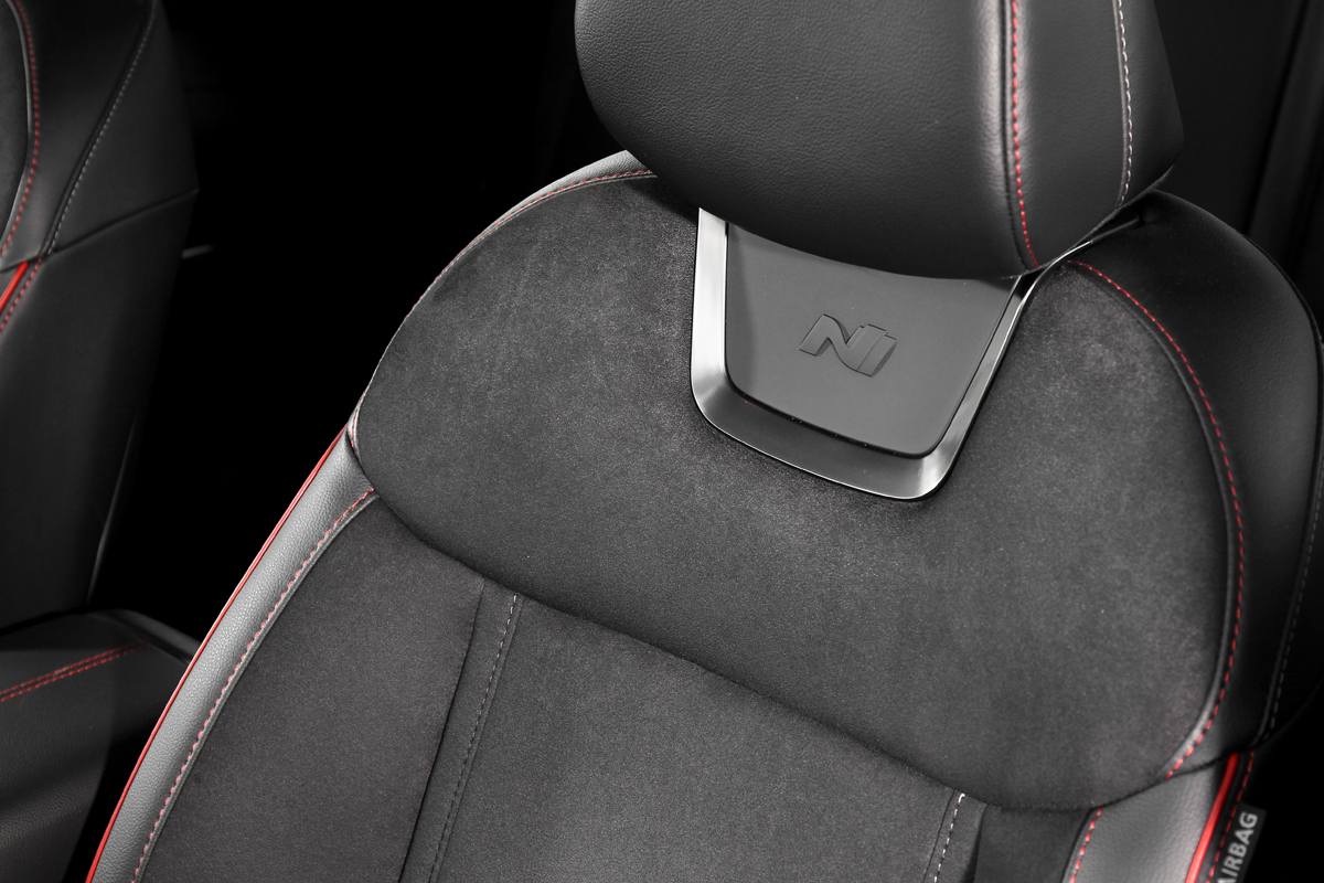 座椅面料改以類麂皮材質鋪陳並施以紅色車縫線點綴，前座頭枕下方更設有類金屬飾框帶出性能識別。